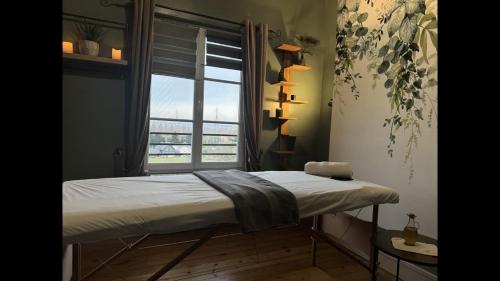 un lit dans une chambre avec une grande fenêtre dans l'établissement Honfleur, Entre Terre & Estuaire, à La Rivière-Saint-Sauveur