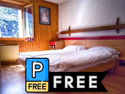 a bedroom with a bed with a free sign next to it at Hotel du Stand in Martigny-Ville