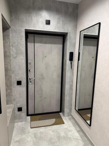 a bathroom with a glass door and a mirror at Апартаменти Зарічанська вулиця Netflix in Khmelʼnytsʼkyy