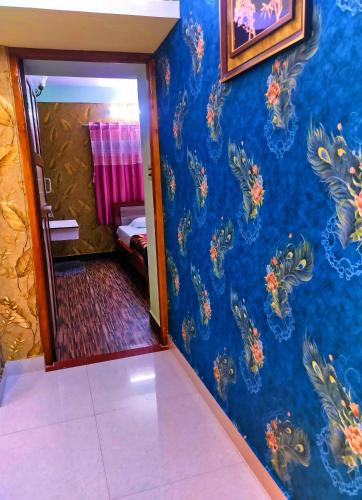 a room with a blue wall with floral wallpaper at Misba Homestay Kodai in Kodaikānāl