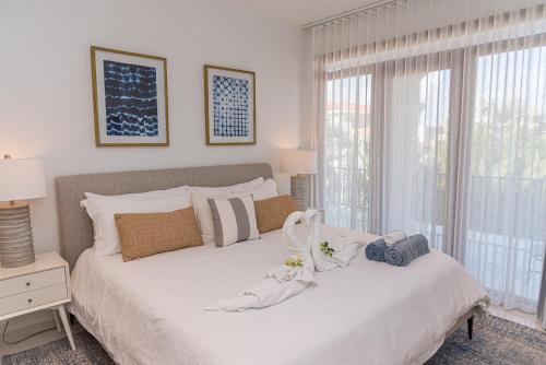 a bedroom with a white bed with a large window at Opal Rental II in Palm-Eagle Beach
