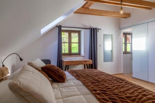 ein Schlafzimmer mit einem großen Bett und einem Schreibtisch in der Unterkunft Peaceful Slovenj Gradec Holiday Villa Escape in Pameče