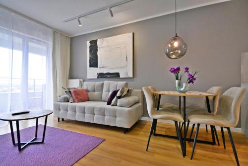 ein Wohnzimmer mit einer Couch und einem Tisch und Stühlen in der Unterkunft Sun Towers - Apartamenty Bryza - Apartamenty z parkingiem in Świnoujście