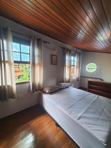a bedroom with a large bed with a wooden ceiling at Suítes Quintal de Lázaro 2 in Ubatuba