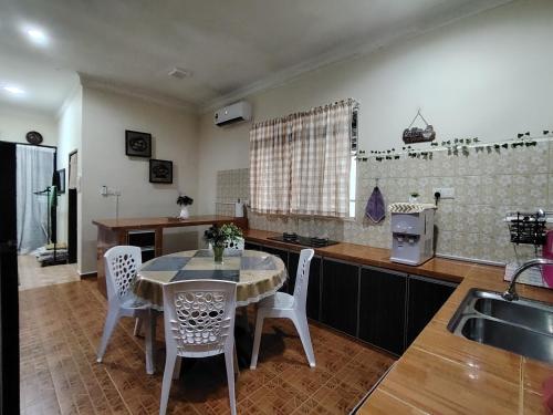 una cucina con tavolo, sedie e lavandino di Sri MaLati Homestay and Event Space a Balik Pulau