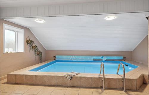 a large swimming pool in a room with at Pet Friendly Home In Ringkøbing in Søndervig