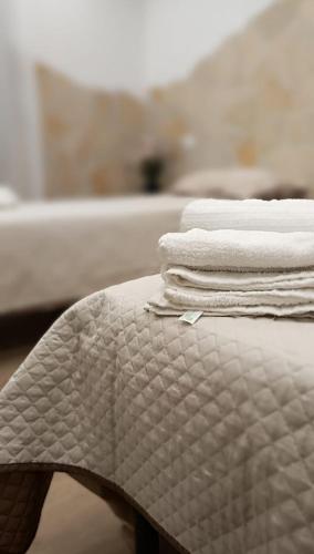 a stack of towels sitting on top of a bed at La Casa di Marty in Ronciglione