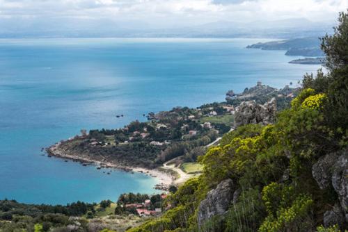 a view of a beach and the ocean from a mountain at Villa Varo by Sicily Travelling Villas in Scopello