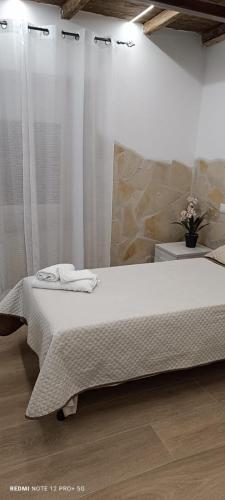 a bedroom with a bed with white sheets on it at La Casa di Marty in Ronciglione
