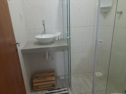 a bathroom with a sink and a glass shower at Pousada Maria de Lino in São Sebastião