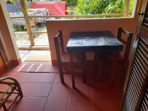 um banco preto sentado ao lado de um alpendre em Pousada Maria de Lino em São Sebastião