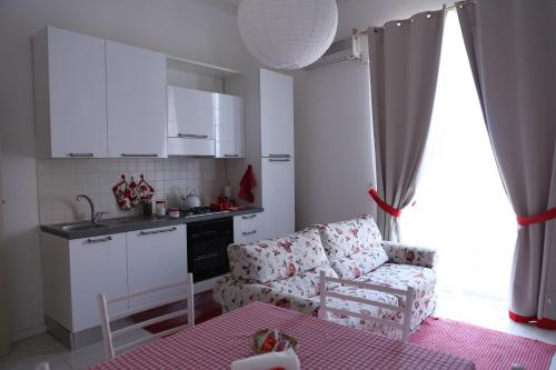 a living room with a couch and a kitchen at San Giorgio by PizzoApartments in Pizzo