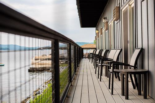 a row of chairs on a balcony overlooking the water at Lake Bomoseen Lodge in Bomoseen
