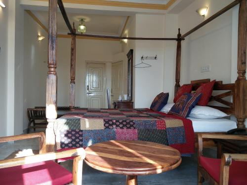 a bedroom with a bed and a table in it at Hotel Pratap Bhawan in Udaipur