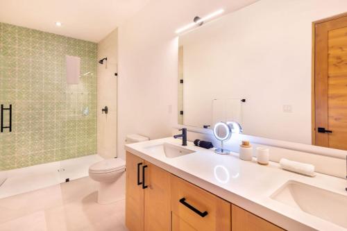 a bathroom with a sink and a toilet and a mirror at Stylish Oceanfront Condo with Panoramic Views in El Pescadero