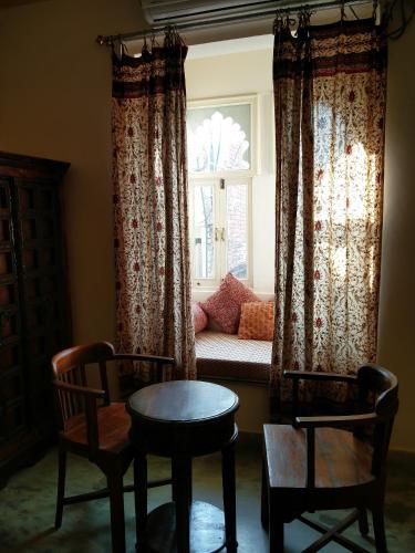 a living room with a couch and a window at Hotel Pratap Bhawan in Udaipur