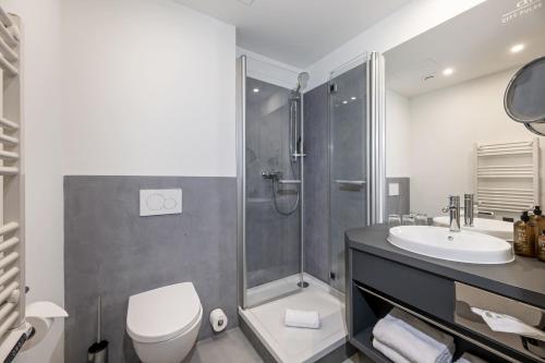 a bathroom with a shower and a toilet and a sink at HOTEL andrä in Salzburg
