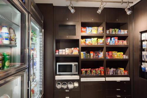 a kitchen with a refrigerator and a microwave at Courtyard by Marriott Oklahoma City North/Quail Springs in Oklahoma City