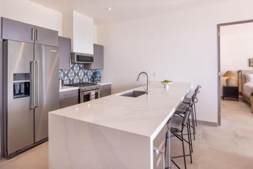 a kitchen with a white counter top and a refrigerator at Boutique Ocean Escape with Relaxing Amenities in El Pescadero