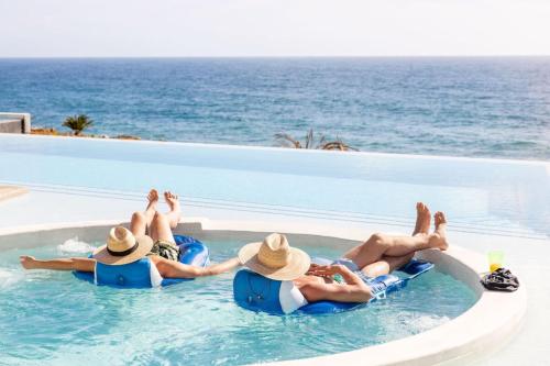 a group of people laying in the swimming pool at a resort at Boutique Ocean Escape with Relaxing Amenities in El Pescadero