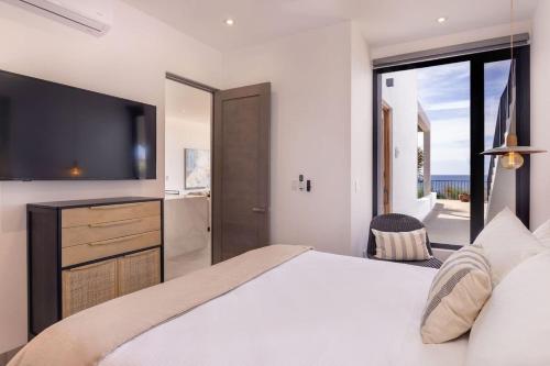 a bedroom with a large bed and a television at Boutique Ocean Escape with Relaxing Amenities in El Pescadero
