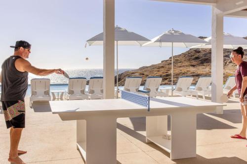 a man standing next to a table and chairs at Boutique Ocean Escape with Relaxing Amenities in El Pescadero