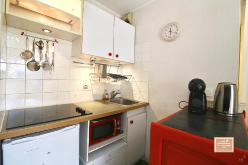 ラ・セーヌ・シュル・メールにあるEscapade cornicheの白いキャビネットとシンクを備えた小さなキッチン