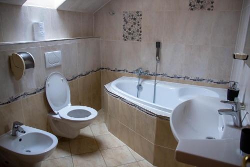 a bathroom with a toilet and a tub and a sink at Zámeček Kaliště in Poddubí