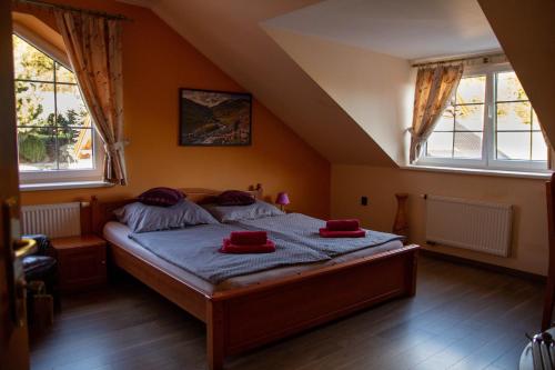 a bedroom with a bed with red pillows on it at Zámeček Kaliště in Poddubí