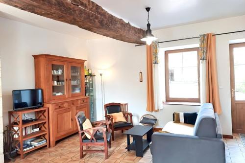un soggiorno con un divano e una TV di Maison de vacances dans grand jardin arboré à La Chapelle-Saint-Fray proche Le Mans Sarthe, Pays-de-la-Loire a Domfront-en-Champagne