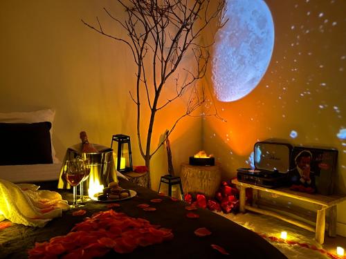 Cette chambre dispose d'une table avec une lune sur le mur. dans l'établissement L'Escapade Romantique, à Cergy