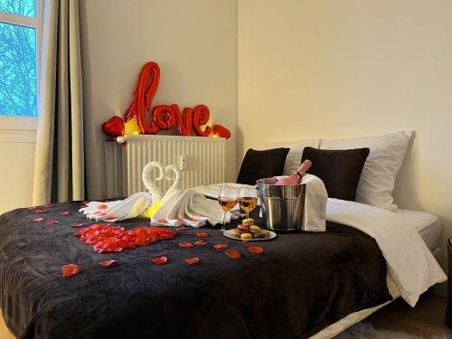 - un lit avec une table et deux verres de vin dans l'établissement L'Escapade Romantique, à Cergy