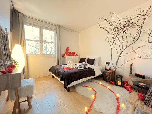 - une chambre avec un lit et un arbre sur le mur dans l'établissement L'Escapade Romantique, à Cergy
