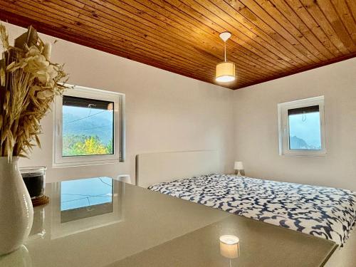 a bedroom with a bed and two windows at Casa da Laurinha in Arcos de Valdevez