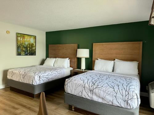 two beds in a hotel room with green walls at St. Croix Inn in Solon Springs