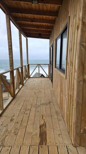 a wooden deck with a view of the ocean at Loft - Vista Curanipe in Curanipe