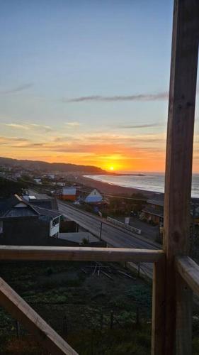 a view of a sunset from a balcony with the ocean at Loft - Vista Curanipe in Curanipe