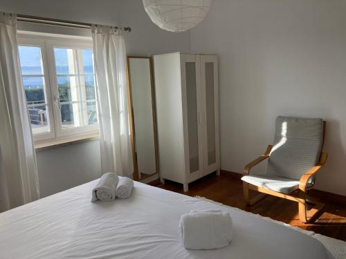 a bedroom with a bed and a chair and a window at FreeSurfCamp & Hostel in Peniche