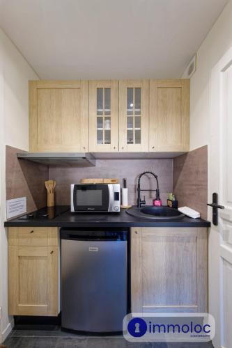 une cuisine avec un évier et un micro-ondes dans l'établissement Studio Auron 300 meters from the cable car, à Auron