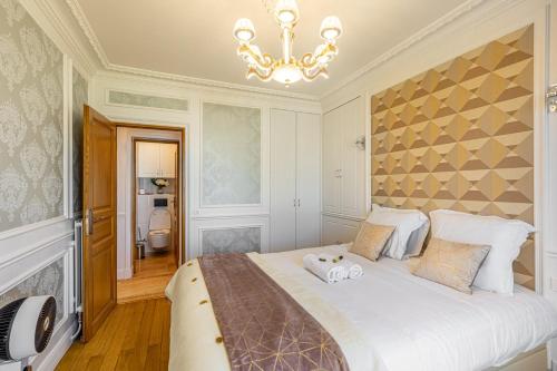 une chambre avec un grand lit et un lustre dans l'établissement GuestReady - Charming Stay near Museum of Illusion, à Paris