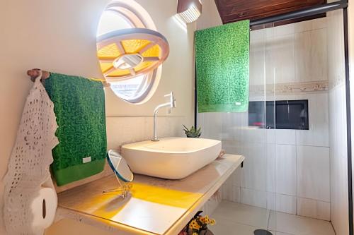 un bagno con un lavandino bianco e uno specchio di "Mi casa, su casa" Em Sorocaba/SP a Sorocaba