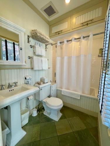 a bathroom with a toilet and a sink and a tub at White Porch Inn in Provincetown