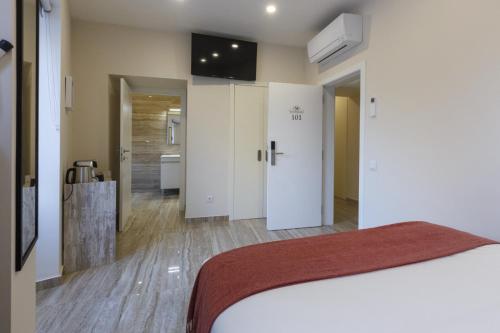 a bedroom with a bed and a bathroom at Solar Mendonca in Faro