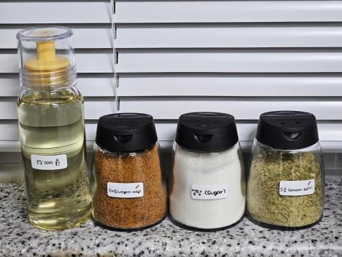 four jars of spices sitting on a counter at Busan Subway 6min #2 Rooms #2 Queen Beds #Hotel Bedding #OTT #Table#1st Floor in Busan