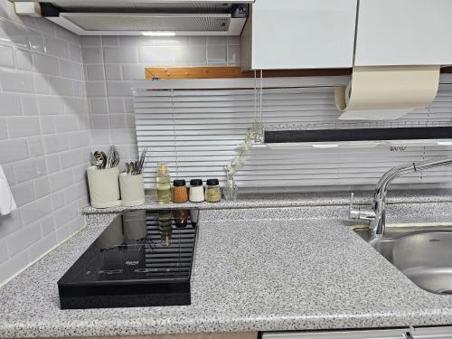 a kitchen with a sink and a counter top at Busan Subway 6min #2 Rooms #2 Queen Beds #Hotel Bedding #OTT #Table#1st Floor in Busan