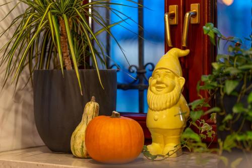 a yellow statue next to a pumpkin and a plant at Great Polonia Dwarf Wrocław in Wrocław