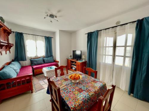 a living room with a table with a bowl of oranges on it at Penthouse prés médina avec vue mer et terrasse in Sousse
