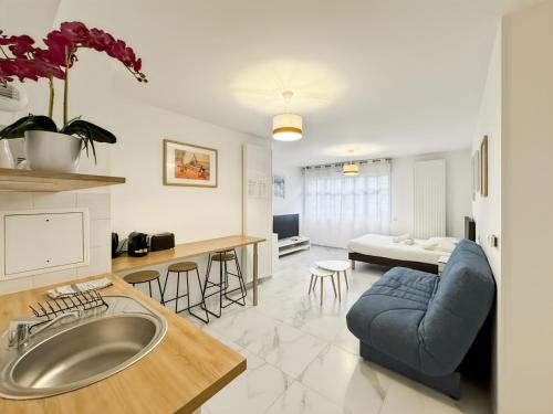 Il comprend un grand salon avec un canapé bleu et une cuisine. dans l'établissement Pré Verson 12 - Studio pour 4 à Disneyland Paris, à Chessy