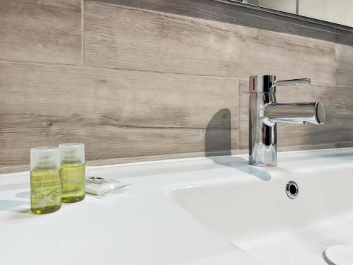 - un lavabo avec deux verres et un robinet dans l'établissement Pré Verson 12 - Studio pour 4 à Disneyland Paris, à Chessy