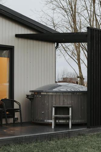 a patio with a grill and a bench next to a house at Light house in Cēsis